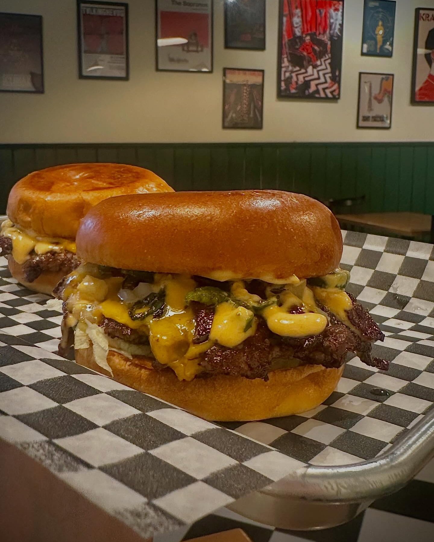A Two Hands cheeseburger on checkered paper: thin crispy-edged patty, melted cheese and a glossy bun